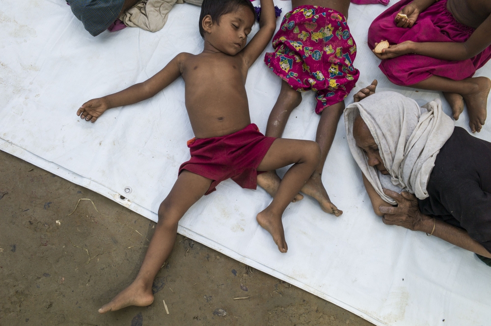 Rohingya Muslim refugees who had just arrived wait for a place to stay at Bangladesh's Balukhali refugee camp on October 2, 2017. The UN says more than 14,100 children are at risk of dying from malnutrition in wretched camps where half a million mainly Rohingya refugees depend entirely on charities for survival. Food distribution in the vastly overcrowded settlements is still ad hoc and uncoordinated, the UN says, more than a month after refugees began pouring into southern Bangladesh to escape ethnic bloodshed in Myanmar.
 / AFP / FRED DUFOUR
