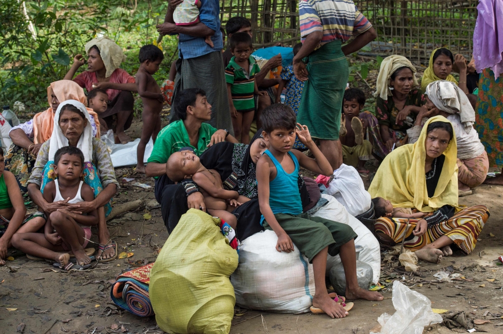 Rohingya Muslim refugees who had just arrived wait for a place to stay at Bangladesh's Balukhali refugee camp on October 2, 2017. The UN says more than 14,100 children are at risk of dying from malnutrition in wretched camps where half a million mainly Rohingya refugees depend entirely on charities for survival. Food distribution in the vastly overcrowded settlements is still ad hoc and uncoordinated, the UN says, more than a month after refugees began pouring into southern Bangladesh to escape ethnic bloodshed in Myanmar.
 / AFP / FRED DUFOUR
