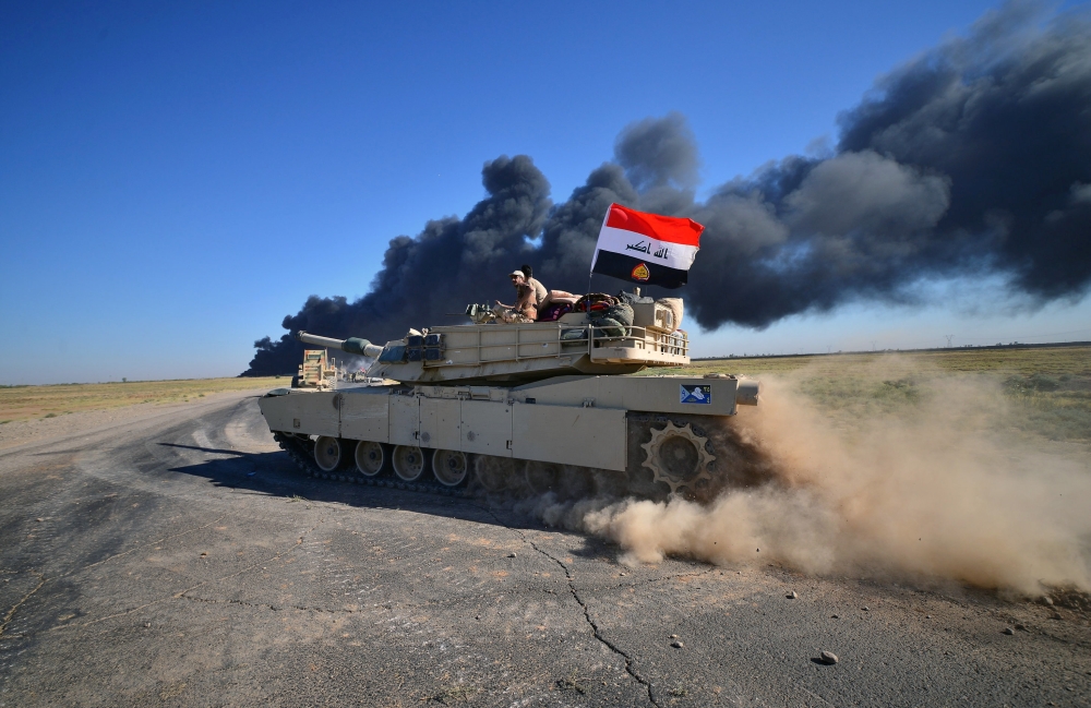 Iraqi army members ride on a tank on the outskirts of Hawija, Iraq October 4, 2017. REUTERS/Stringer NO RESALES. NO ARCHIVES   TPX IMAGES OF THE DAY