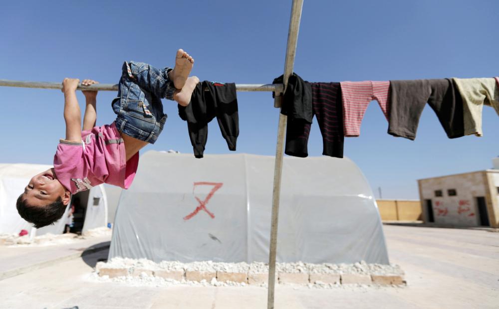 Internally displaced Syrian boy plays outside a camp in the town of Soussian in Aleppo countryside, Syria, October 6, 2017. REUTERS/Khalil Ashawi TPX IMAGES OF THE DAY