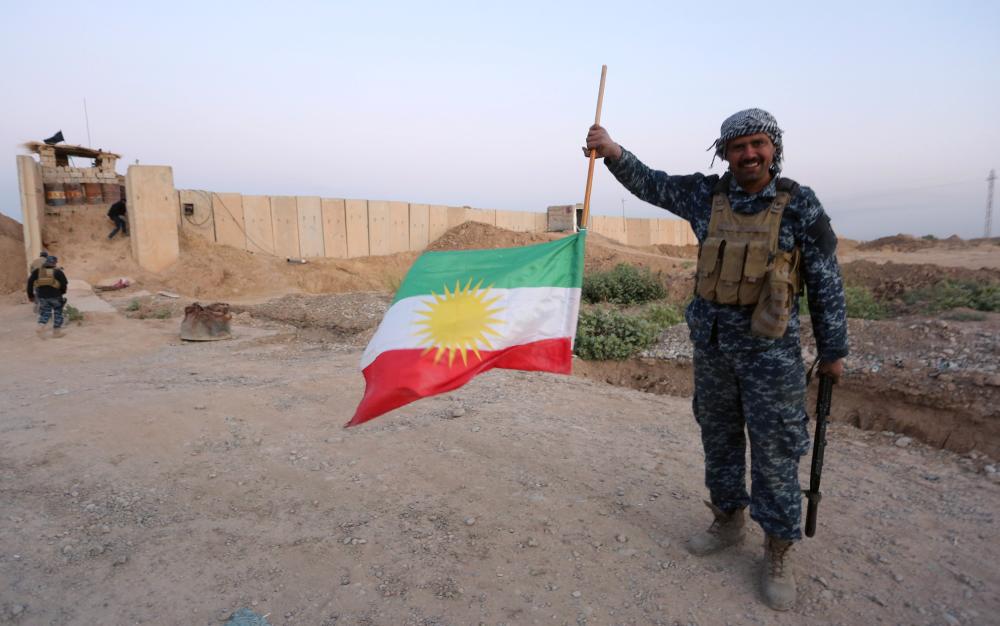 REFILE - ADDING INFORMATION A member of Iraqi federal forces holds the Kurdish flag upside down after Iraq's central government forces seized Kurdish positions in Kirkuk, Iraq October 16, 2017. REUTERS/Stringer NO RESALES. NO ARCHIVES