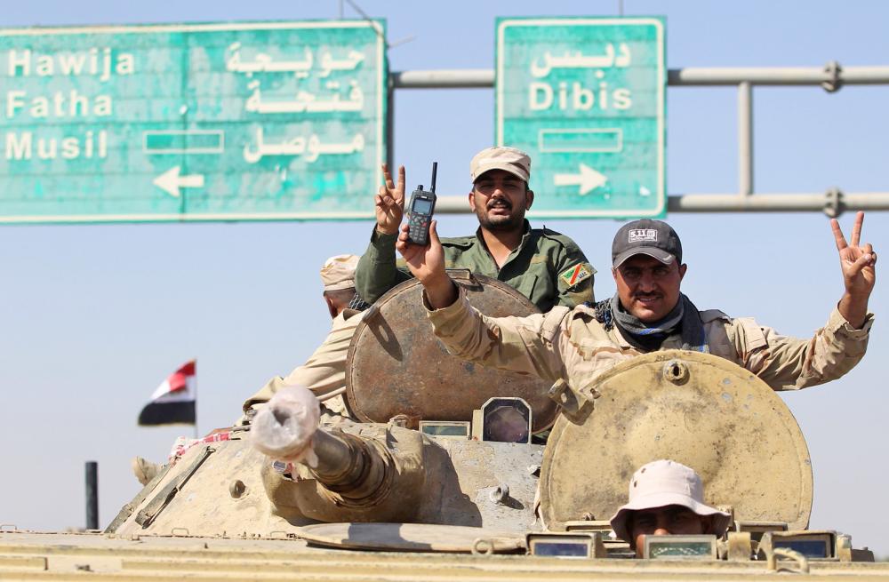



.. وجنديان عراقيان يرفعان علامة النصر. (أ. ف. ب)