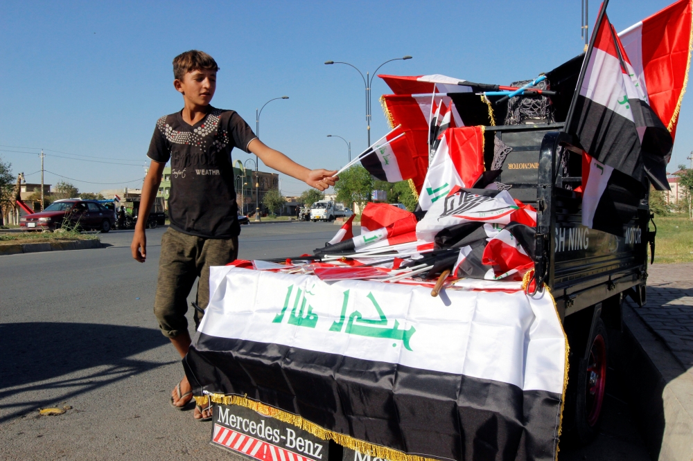 A boy sells Iraqi flags on a street in Kirkuk, Iraq October 19, 2017. REUTERS/Ako Rasheed