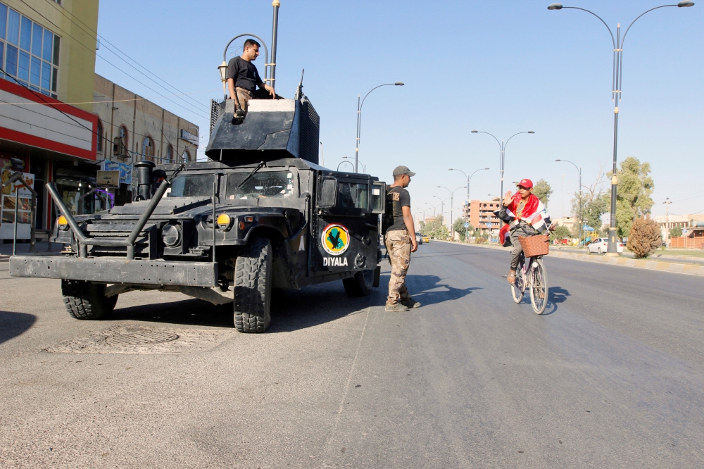 A cyclist gestures at Iraqi security forces, on a street of Kirkuk, Iraq October 19, 2017. REUTERS/Ako Rasheed