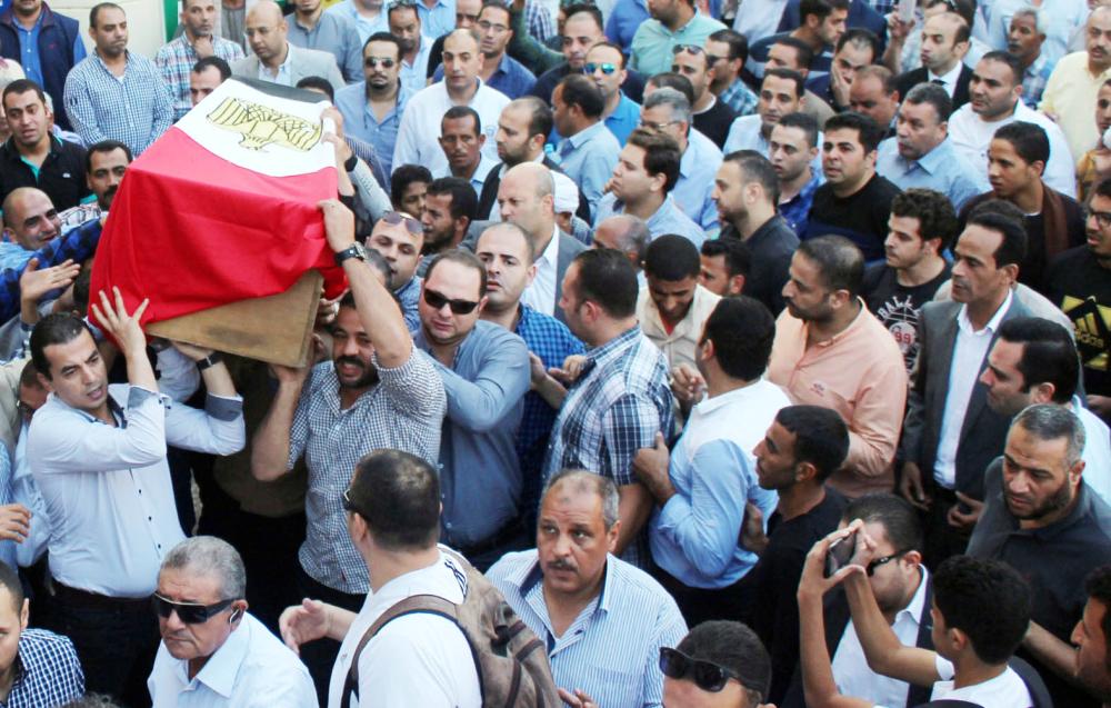 



مصريون يحملون جثمان ضابط الشرطة أحمد فايز الذي قتل في هجوم الواحات أمس الأول. (رويترز)