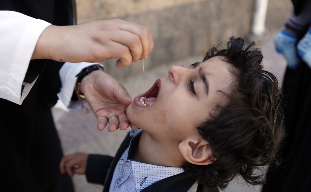 طفل يتلقى تطعيما ضد شلل الأطفال وسط تفشي الأوبئة بسبب منع الميليشيات دخول المواد الطبية لصنعاء. (ا.ف.ب)