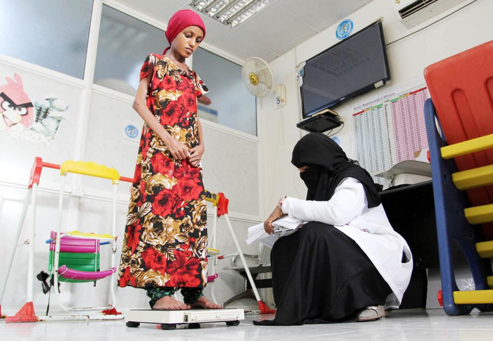 



 فتاة يمنية تعاني من سوء التغذية الحاد، تقف على ميزان في مستشفى الثورة في الحديدة التي يحاصرها الانقلابيون أمس.  (رويترز)