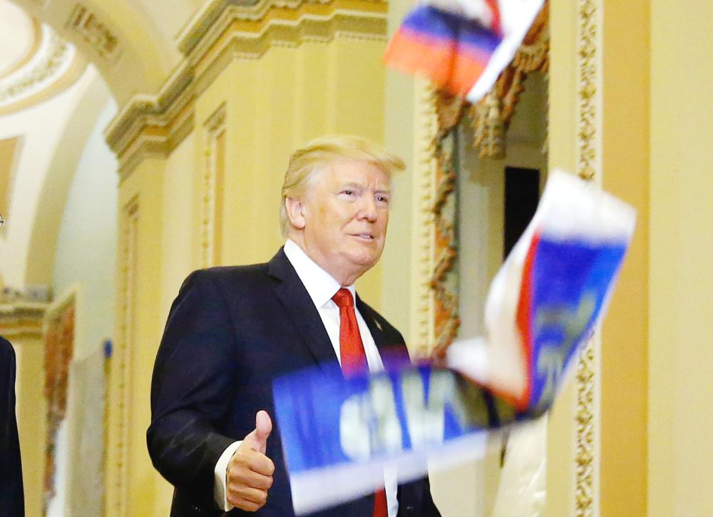 



لحظة رمي الرئيس الأمريكي ترمب بالأعلام الروسية في الكونغرس أمس. (رويترز)