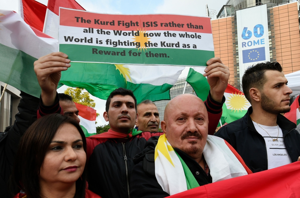 Kurdish protesters shout slogans and brandish placards during a demonstration outside EU headquarters in Brussels on October 25, 2017, as they gather to denounce recent violence in Kurdistan and the alleged passive attitude of the EU towards events there. / AFP / JOHN THYS
