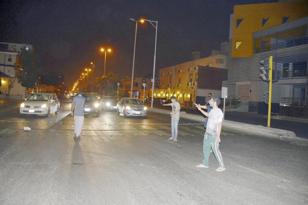 





عدد من أبناء الحي ينظمون الحركة المرورية في ظل غياب رجال المرور. (تصوير عبدالسلام السلمي)