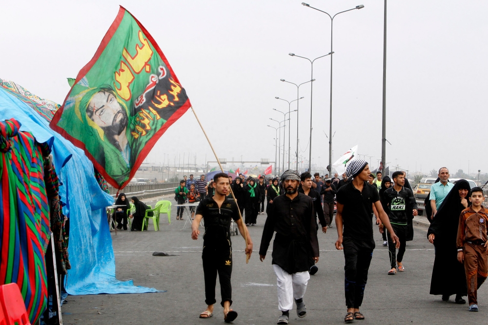 Shiite Muslim pilgrims walk on a road on the southern outskirts of Baghdad as they head towards the holy city of Karbala on November 4, 2017 a week ahead of the Arbaeen religious festival, which marks the 40th day after Ashura, commemorating the seventh century killing of Prophet Mohammed's grandson, Imam Hussein.  / AFP / SABAH ARAR
