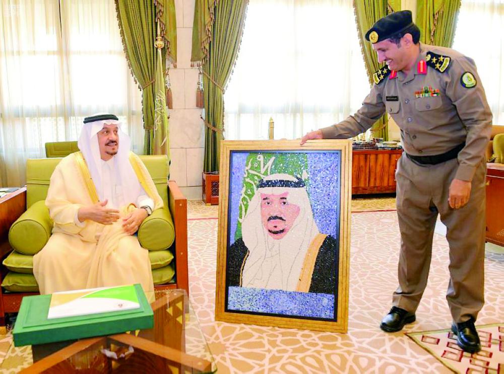



الأمير فيصل بن بندر متسلما لوحة مقدمة من إحدى نزيلات السجون. (عكاظ)