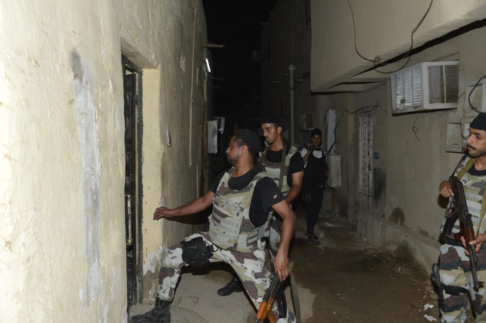 القوات الأمنية أثناء مداهمة أحد البيوت المخالفة.