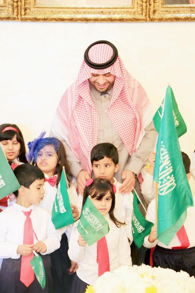 الأمير فيصل بن خالد مع عدد من أطفال فريق جيل الغد. (عكاظ) 