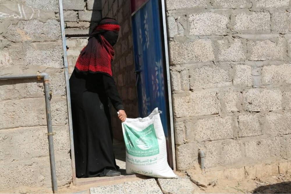 امرأة يمنية تتناول إحدى المساعدات