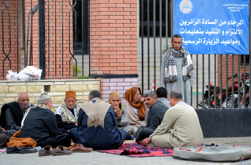 TOPSHOT - Relatives of the victims of the bomb and gun assault on the North Sinai Rawda mosque wait outside the Suez Canal University hospital in the eastern port city of Ismailia on November 25, 2017, where they were taken to receive treatment following the deadly attack the day before. Egypt's President Abdel Fattah al-Sisi vowed on November 24 to respond forcefully after the attackers killed at least 235 worshippers in the packed mosque in restive North Sinai province, the country's deadliest attack in recent memory. / AFP / MOHAMED EL-SHAHED
