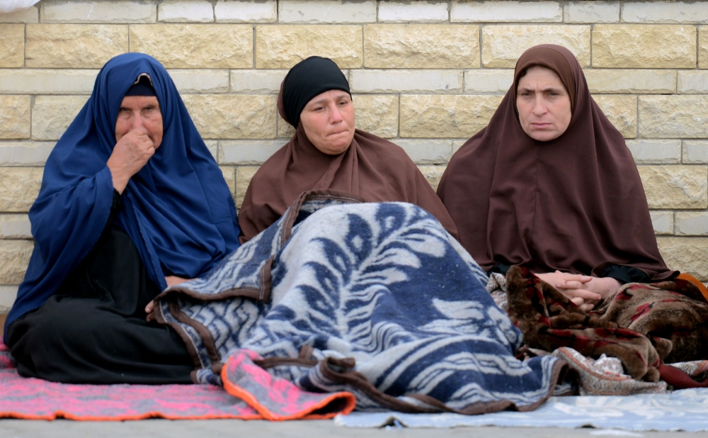 Relatives of the victims of the bomb and gun assault on the North Sinai Rawda mosque sit outside the Suez Canal University hospital in the eastern port city of Ismailia on November 25, 2017, where they were taken to receive treatment following the deadly attack the day before. Egypt's President Abdel Fattah al-Sisi vowed on November 24 to respond forcefully after the attackers killed at least 235 worshippers in the packed mosque in restive North Sinai province, the country's deadliest attack in recent memory. / AFP / MOHAMED EL-SHAHED
