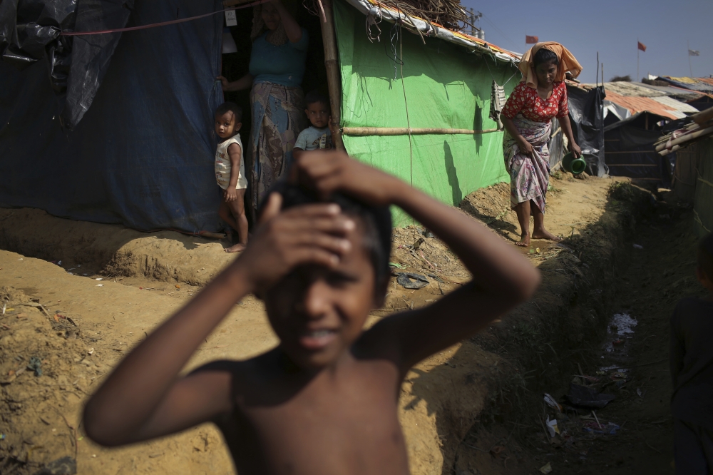 A Rohingya boy plays outside his family's tent in Kutupalong refugee camp on Saturday, Nov. 25, 2017, in Bangladesh.  The United Nations and others have said the military's actions appeared to be a campaign of 