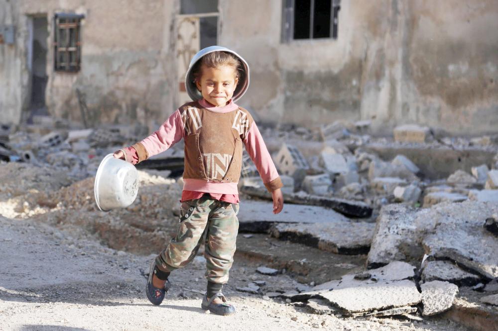 



طفل سوري يسعى ليسدَّ رمقه في بلدة النشابية بمنطقة دوما أمس الأول. (أ ف ب)