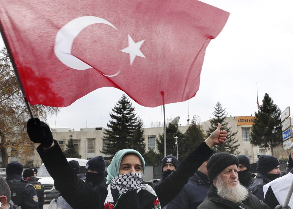 Demonstrators hold Turkish flags and placards during a protest against the US intention to move the US embassy from Tel Aviv to Jerusalem and to recognize the city of Jerusalem as the capital of Israel, near the US Embassy in Ankara on December 7, 2017. US President Donald Trump's recognition of Jerusalem as Israel's capital prompted an almost universal diplomatic backlash that continued today, with fresh warnings from Turkey, the European Union and Russia.
 / AFP / Adem ALTAN
