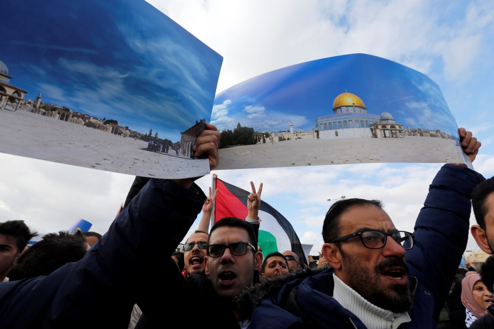 Protesters hold pictures of Aqsa mosque during a protest near the American Embassy in Amman, Jordan December 7, 2017. REUTERS/Muhammad Hamed