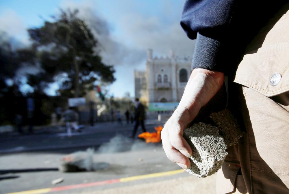 A Palestinian protester holds stones during clashes with Israeli troops as Palestinians call for a 