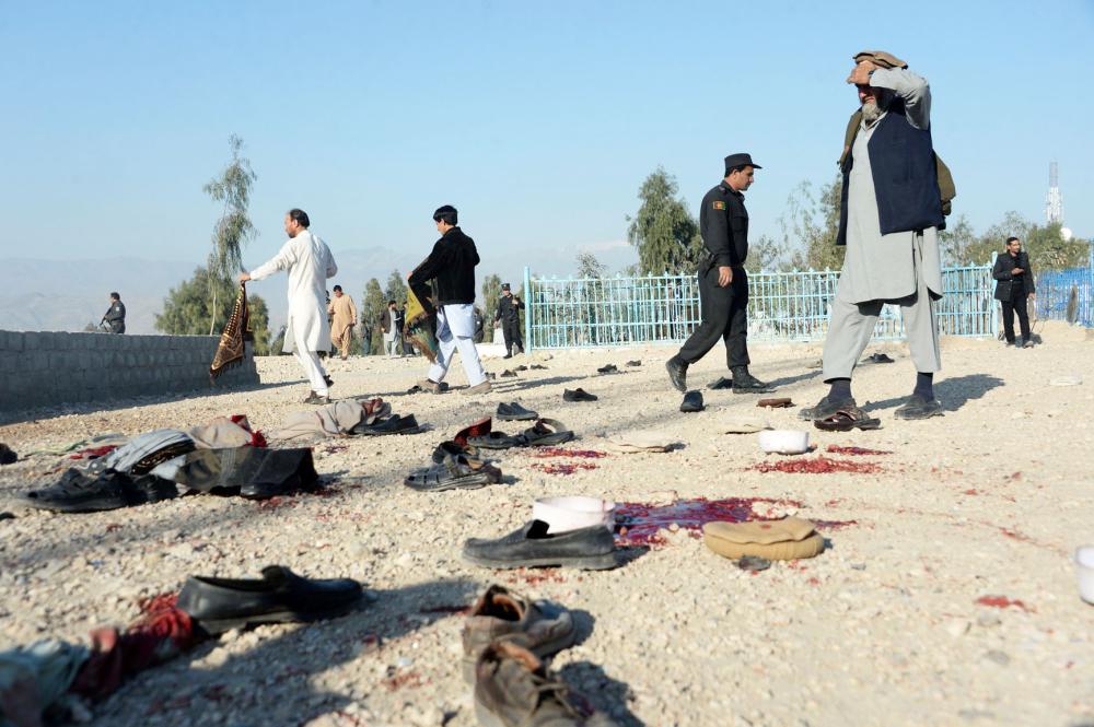 



أفراد أمن أفغان يتفقدون موقع الهجوم الانتحاري في نانغرهار أمس. (أ ف ب)