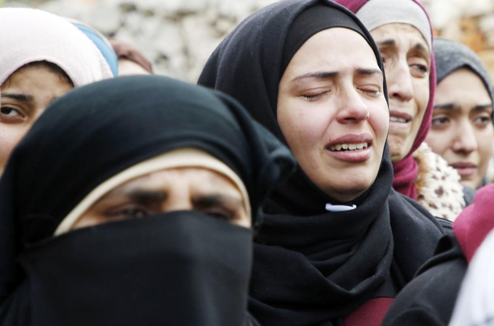 



فلسطينية تذرف الدمع أمس أثناء تشييع جنازة قريب لها قتل برصاص الاحتلال في الضفة. (رويترز)