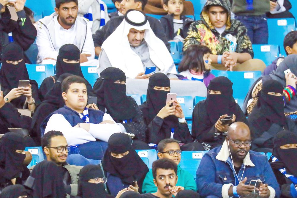 Female supporters of Saudi's Al-Hilal attend their team's football match against Al-Ittihad in the Saudi Pro League at the King Fahd International Stadium in Riyadh on January 13, 2018. Saudi Arabia allowed women to enter a football stadium for the first time to watch a match on January 12, as the ultra-conservative kingdom eases strict decades-old rules separating the sexes. / AFP / Ali AL-ARIFI
