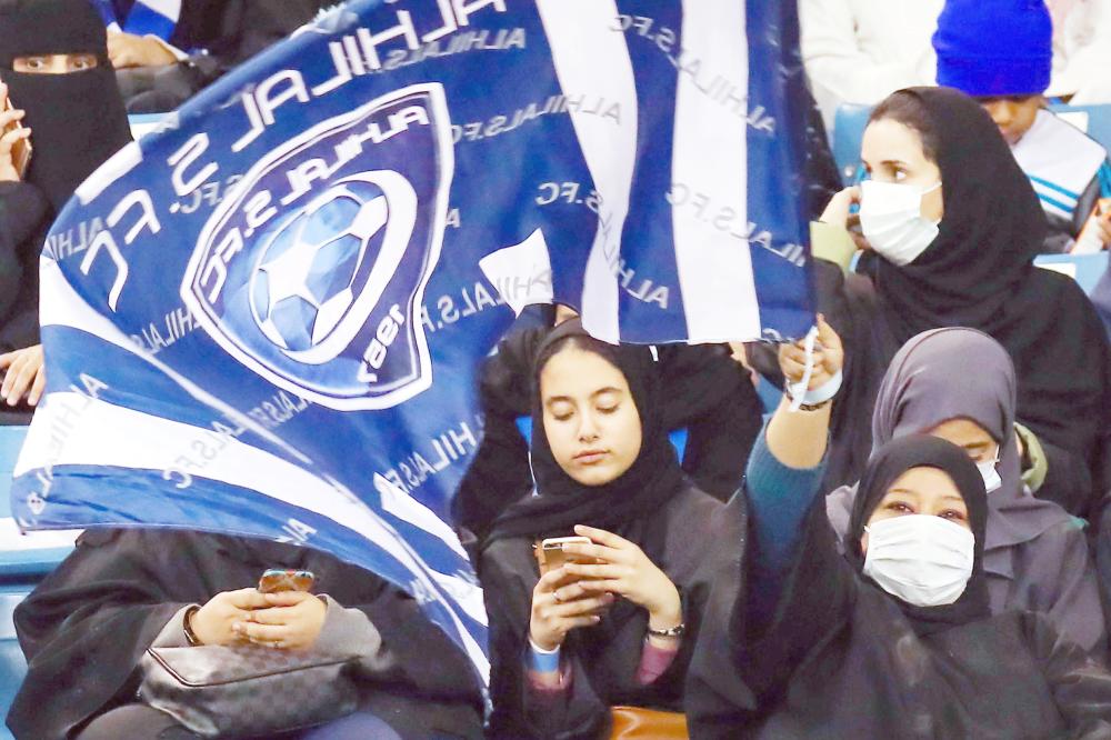 Female supporters of Saudi's Al-Hilal attend their team's football match against Al-Ittihad in the Saudi Pro League at the King Fahd International Stadium in Riyadh on January 13, 2018. Saudi Arabia allowed women to enter a football stadium for the first time to watch a match on January 12, as the ultra-conservative kingdom eases strict decades-old rules separating the sexes. / AFP / Ali AL-ARIFI
