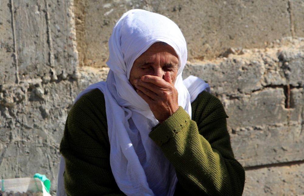 مسنة فلسطينية تبكي أثناء تشييع جثمان شاب في الضفة الغربية أمس. (رويترز)