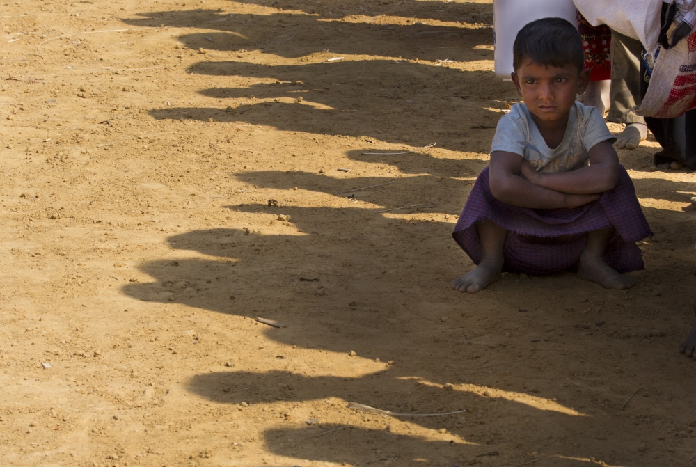 A Rohingya refugee boy sits in queue with others to receive food packets at Balukhali refugee camp, 50 kilometres (32 miles) from, Cox's Bazar, Bangladesh, Thursday, Jan. 18, 2018. Bangladesh and Myanmar have agreed that they will try to complete the repatriation of hundreds of thousands of Rohingya Muslim refugees who fled from violence in Myanmar within two years, Bangladesh's Foreign Ministry said. (AP Photo/Manish Swarup)
