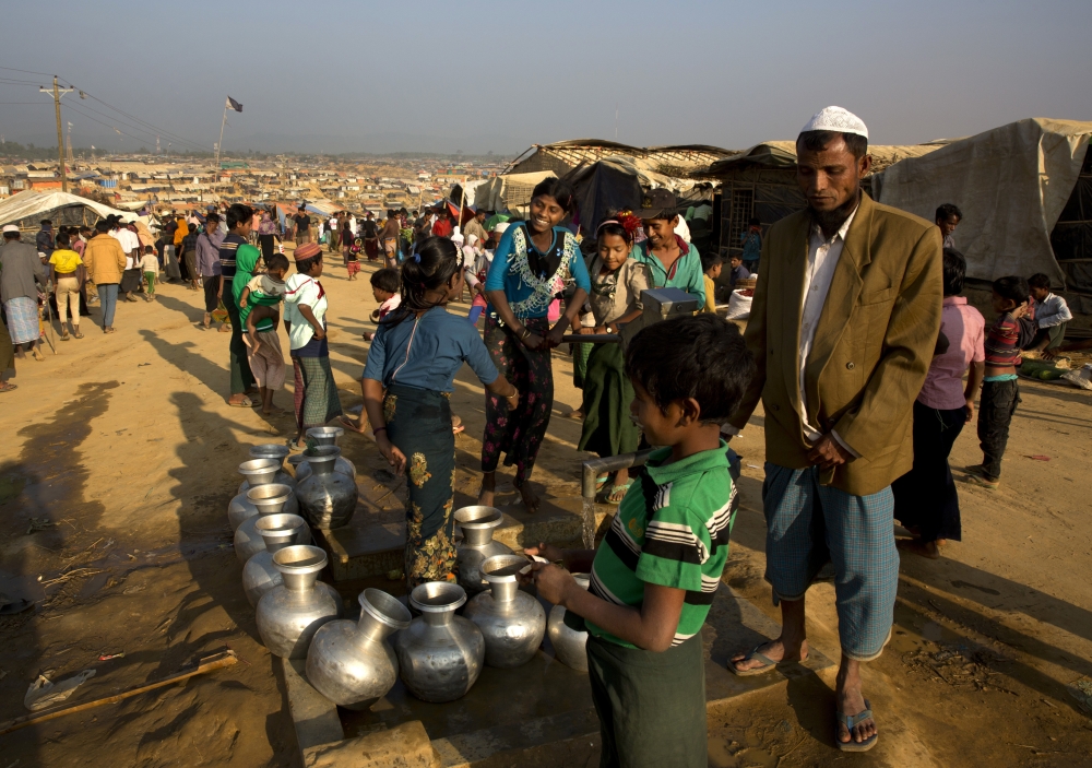 Rohingya refugee children fill drinking water from a hand pump at Balukhali refugee camp, 50 kilometres (32 miles) from, Cox's Bazar, Bangladesh, Thursday, Jan. 18, 2018. Bangladesh and Myanmar have agreed that they will try to complete the repatriation of hundreds of thousands of Rohingya Muslim refugees who fled from violence in Myanmar within two years, Bangladesh's Foreign Ministry said. (AP Photo/Manish Swarup)