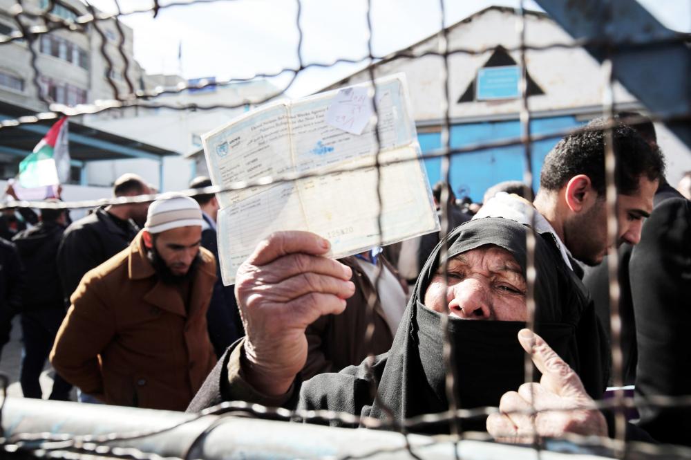 



مسنة فلسطينية تلوح بوثيقة صادرة عن «الأونروا» خلال مظاهرة أمام مقر الوكالة في غزة أمس. (أ ف ب)