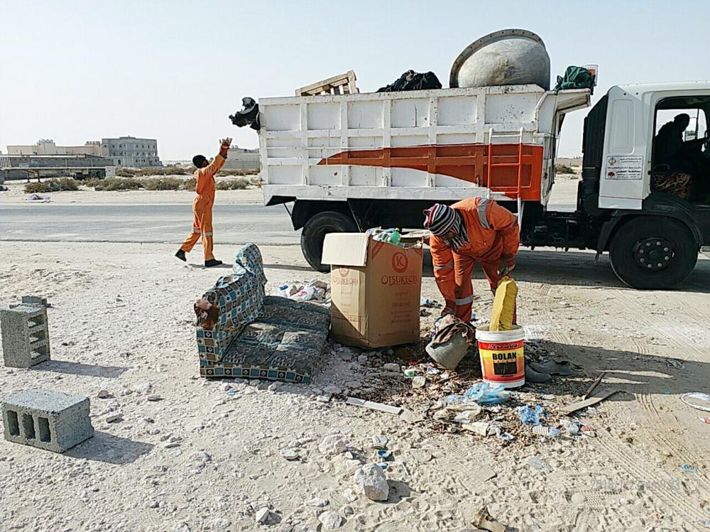 عمال بلدية الخفجي أثناء رفع النفايات. (عكاظ)