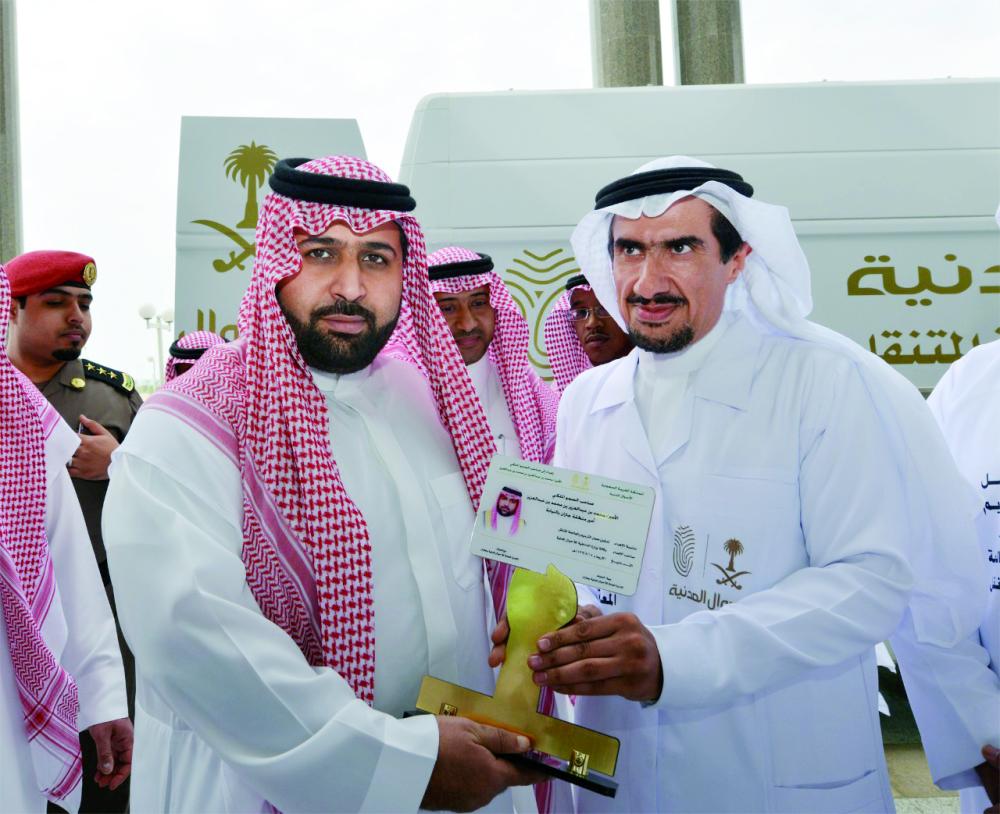



الأمير محمد بن عبدالعزيز متسلما درعا عليه مجسم هويته الوطنية. (عكاظ) 