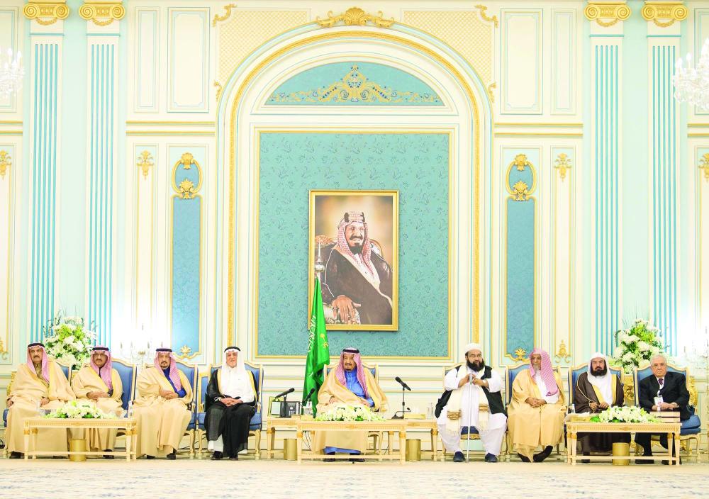 الملك سلمان مستقبلا ضيوف «الجنادرية 32» من الأدباء والمفكرين أمس في الرياض. (واس)