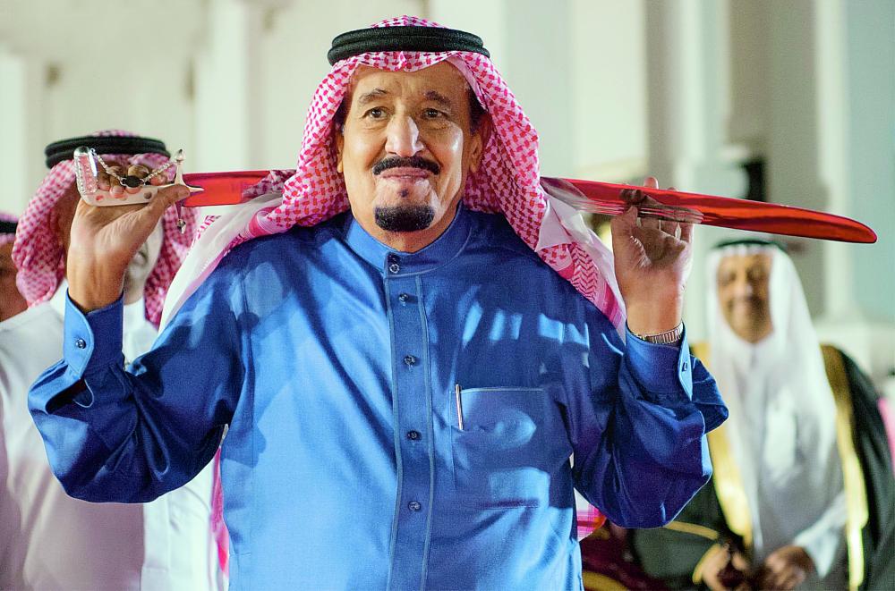 الملك سلمان يؤدي العرضة السعودية.