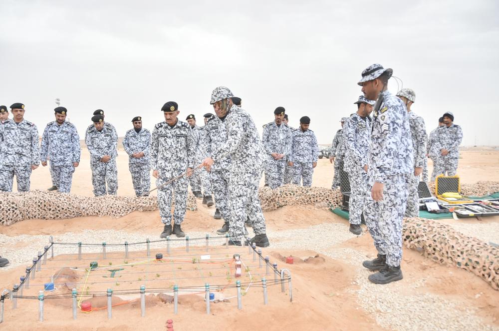 مدير عام كلية الملك فهد أثناء استماعه لشرح لأحد الطلبة. (عكاظ)