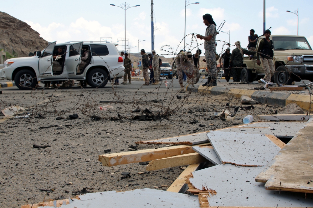 Security personnel inspect the site of a car bomb attack outside the headquarters of a counter-terrorism unit in Aden, Yemen February 25, 2018. REUTERS/Fawaz Salman