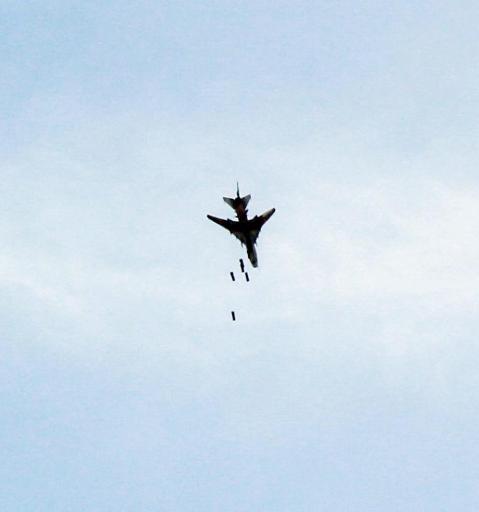 A picture taken on March 9, 2018 shows a Syrian air force plane dropping a payload as it flies over the rebel-held enclave of Eastern Ghouta on the eastern outskirts of the capital Damascus.  / AFP / HAMZA AL-AJWEH
