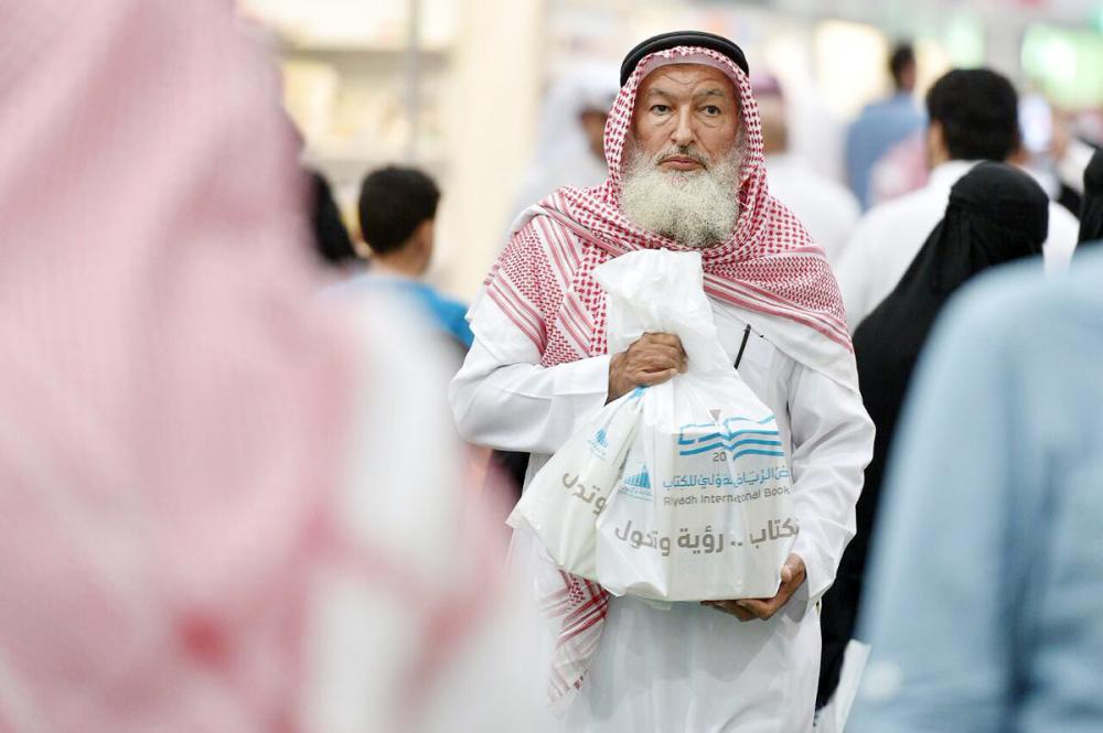 



مواطن يقتني مجموعة من الكتب من معرض الرياض العام الماضي. (عكاظ)