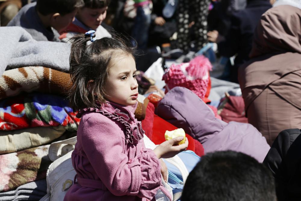 Syrian civilians evacuated from rebel-held areas in the Eastern Ghouta enclave gather at a school in the regime-controlled Adra district, on the northeastern outskirts of the capital Damascus, on March 16, 2018. Thousands of civilians poured out of Eastern Ghouta after a month-long bombardment brought the Syrian regime closer to recapturing the devastated rebel enclave outside Damascus. / AFP / LOUAI BESHARA
