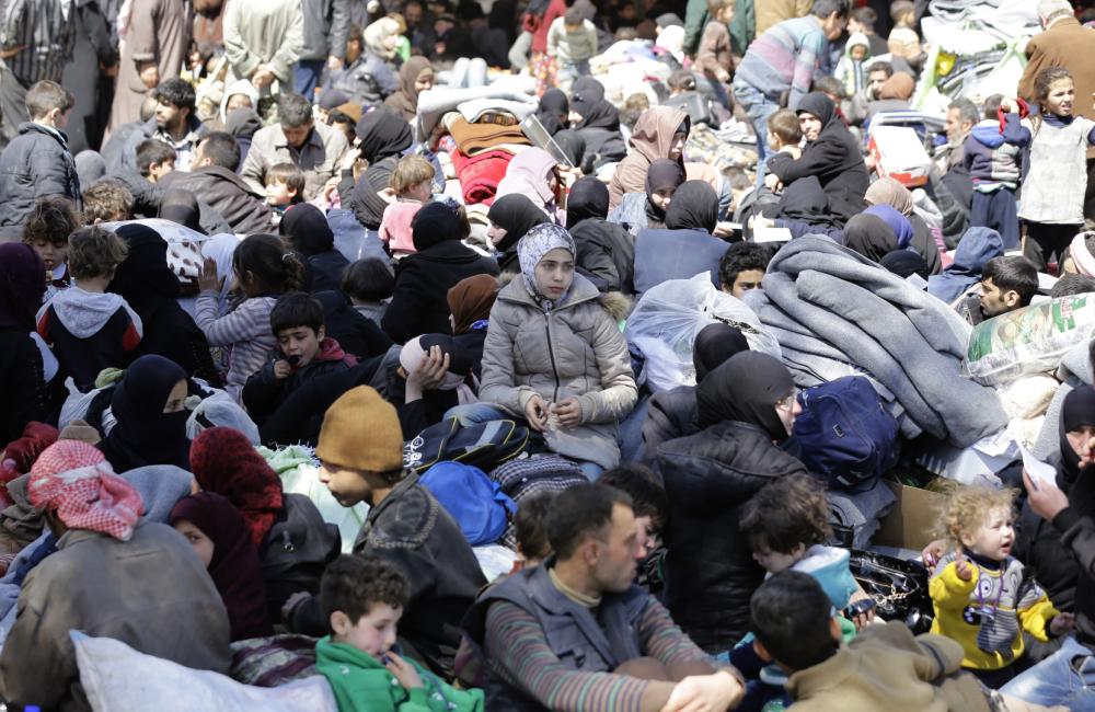 Syrian civilians evacuated from rebel-held areas in the Eastern Ghouta enclave gather at a school in the regime-controlled Adra district, on the northeastern outskirts of the capital Damascus, on March 16, 2018. Thousands of civilians poured out of Eastern Ghouta after a month-long bombardment brought the Syrian regime closer to recapturing the devastated rebel enclave outside Damascus. / AFP / LOUAI BESHARA
