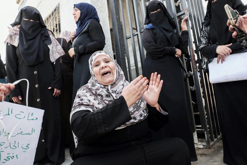 فلسطينية تشارك في مظاهرة احتجاج على غلق معبر رفح بين غزة ومصر أمس. (أ.ف.ب)