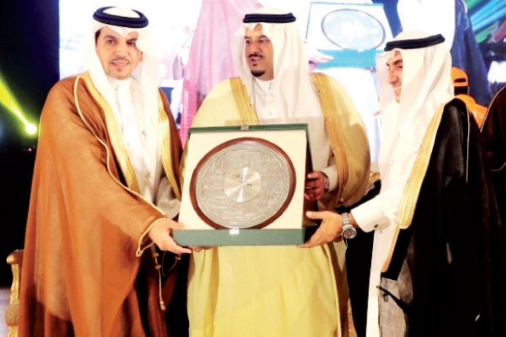 تركي الفوزان يتسلّم تكريم البنك الأهلي من نائب أمير الرياض. (عكاظ)