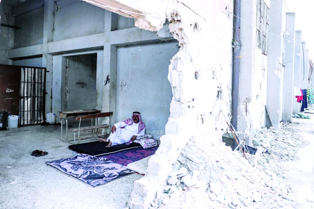 



رجل يجلس في حجرة مدمرة داخل مدرسة تستخدم من قبل النازحين من الغوطة الشرقية، في بلدة عطارب. (إي ب أ)