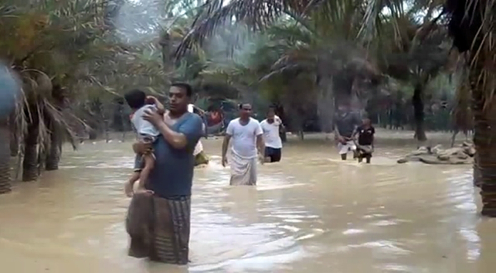 An image grab taken from an AFPTV video shows people walking through flood water as they evacuate a flooded area during a cyclone in the Yemeni island of Socotra. Seven people were missing and hundreds others evacuated from their homes after a cyclone hit the Yemeni island the previous night, causing severe flooding and damage to houses, officials said.
 / AFP / AFPTV / STRINGER
