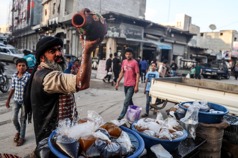 بائع يروج لمشروباته قبيل أذان المغرب في بلدة اعزاز شمال ريف حلب