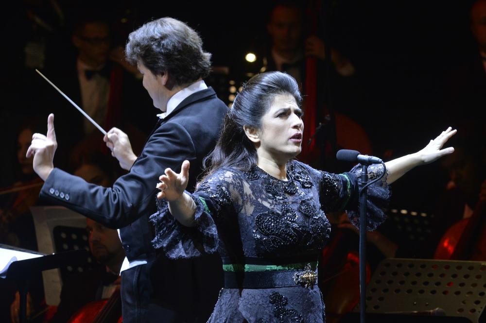 epa06817675 Lebanese opera singer and composer Hiba Al Kawas (R) performs on the stage during an Eid al-Fitr celebration organized by the General Culture Authority in Saudi Arabia, featuring the Kiev Virtuosi Orchestra conducted by Karl Sollak (L), at the Princess Nora bint Abdul Rahman University in Riyadh, Saudi Arabia, 17 June 2018 (issued 18 June 2018). Muslims around the world are celebrating Eid al-Fitr, the three day festival marking the end of the Muslim holy month of Ramadan, it will be observed on 15th or 16th of June depending on the lunar calendar. Eid al-Fitr is one of the two major holidays in Islam.  EPA/WAEL HAMZEH